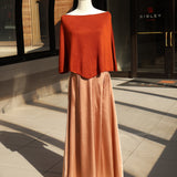 Orange poncho knit top with a slouchy neckline displayed on a mannequin.