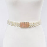 Ivory belt with pearl detailing and a decorative clasp on a mannequin.