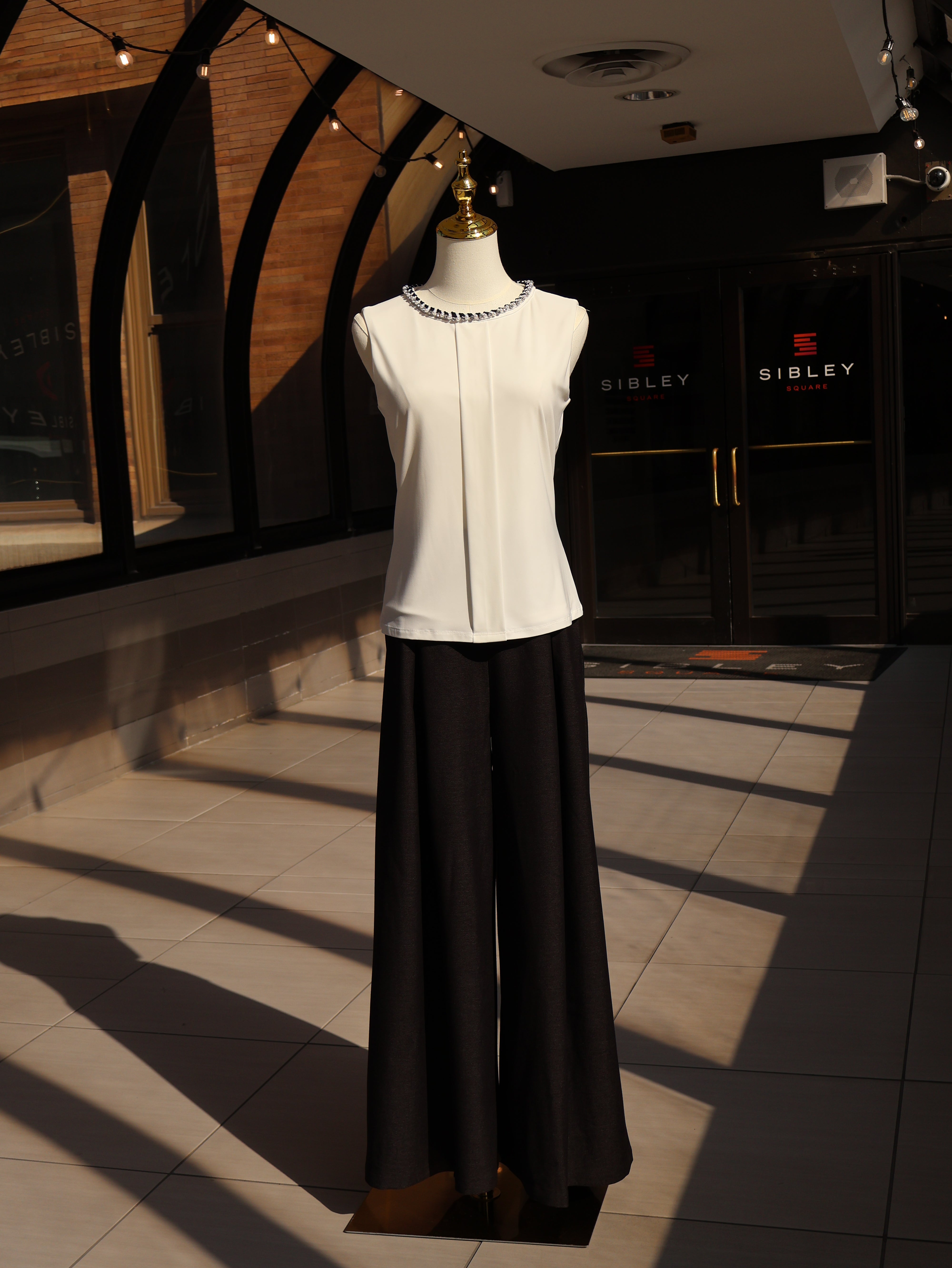Black chambray palazzo pants with a relaxed fit and long silhouette displayed on a mannequin.