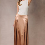 A khaki satin midi skirt with a high waist and invisible zipper, worn by a model with a white top.