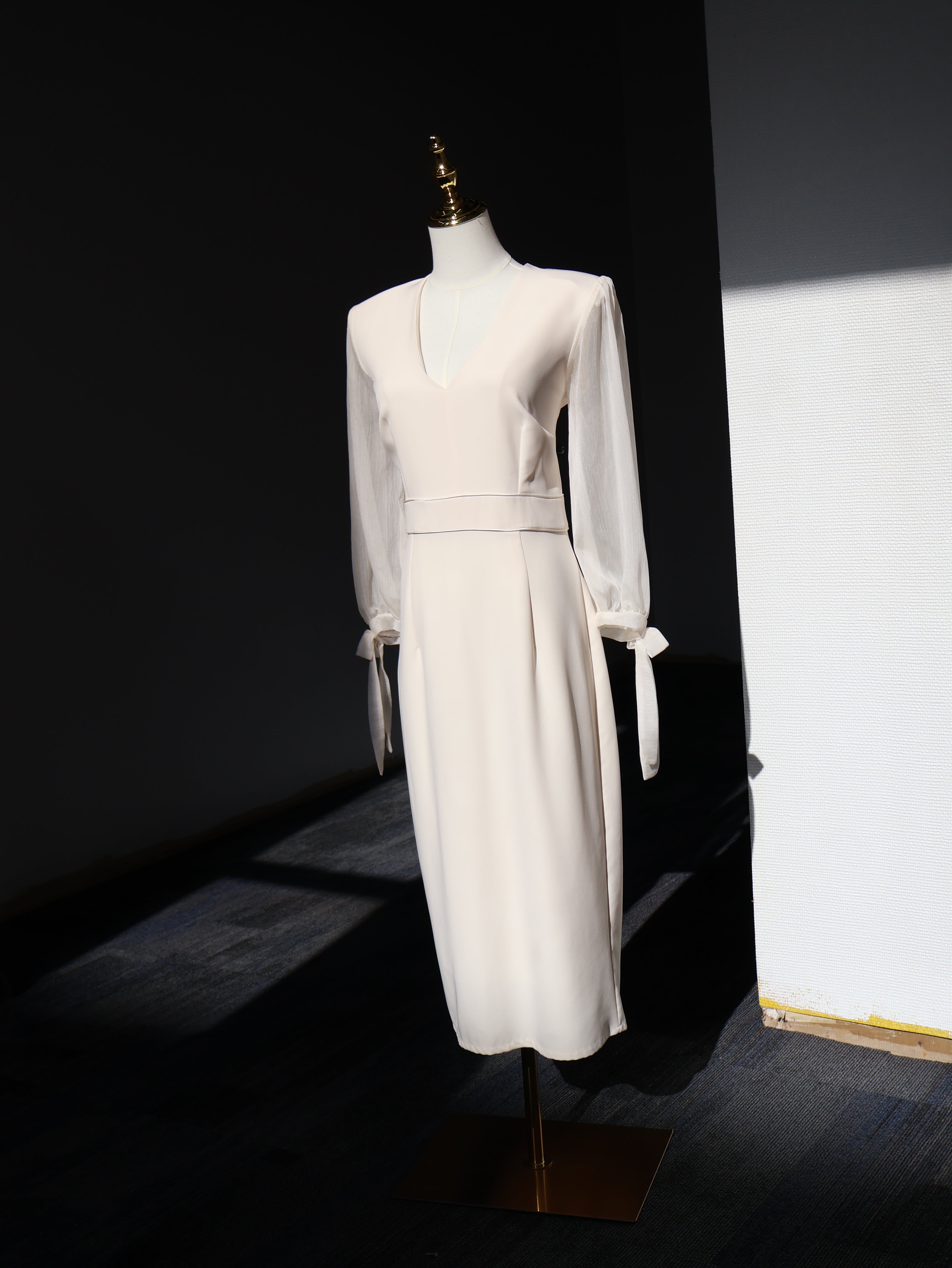 Ivory Reverie Midi Dress in white with V-neckline and long chiffon sleeves displayed on a mannequin.