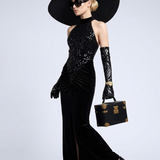 A woman wearing a black halter-style gown with sequins and a mermaid-cut skirt.