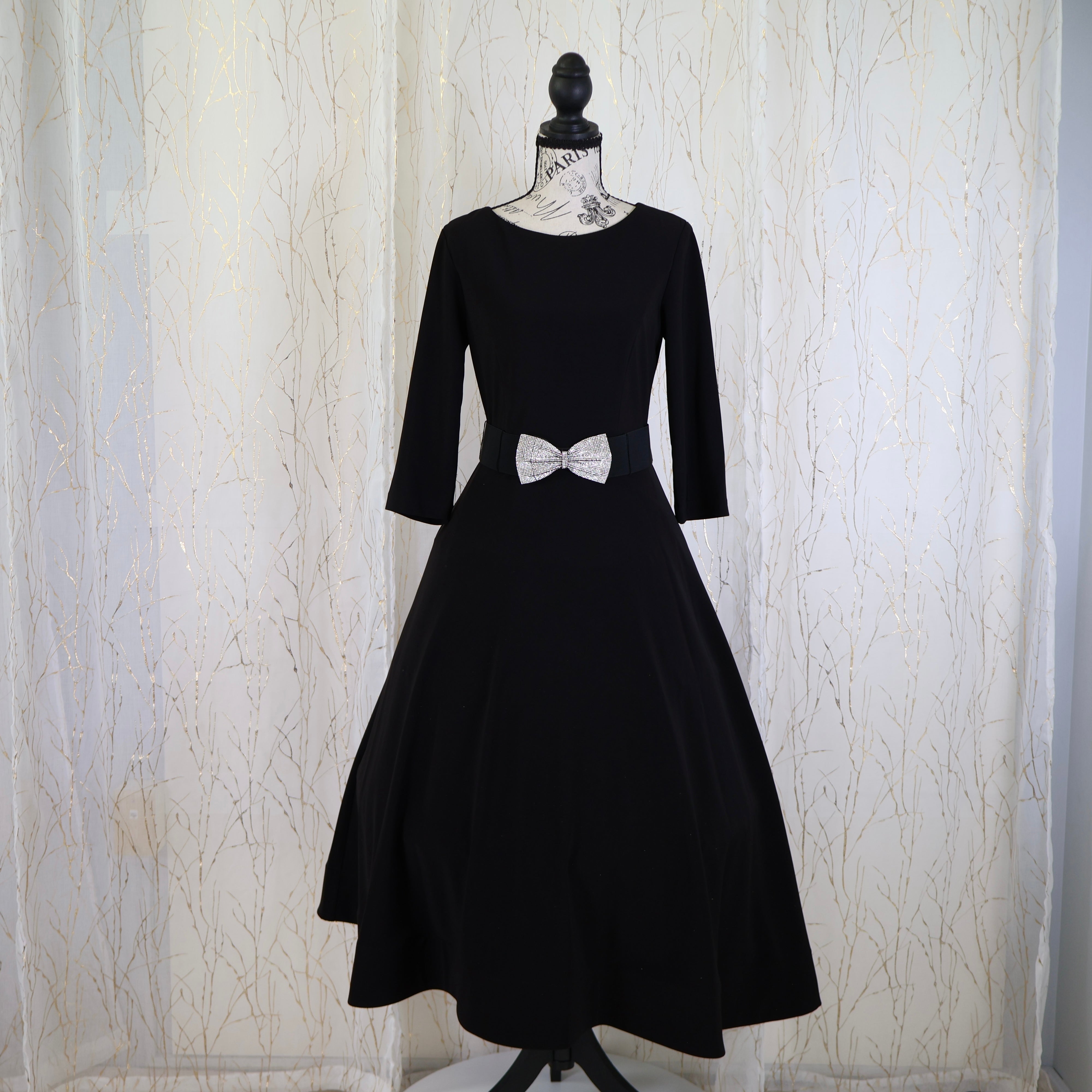 Black formal dress with a flattering silhouette and sophisticated design, featuring a bow detail at the waist.